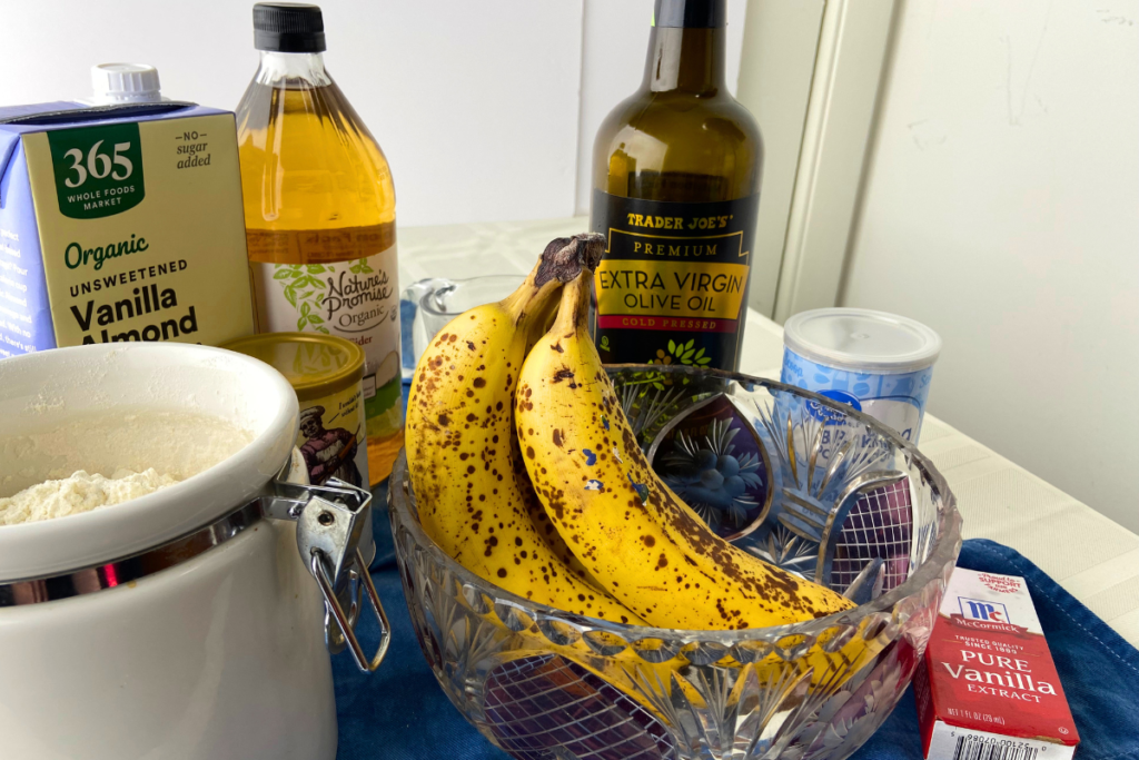 Ingredients for vegan banana muffins that include almond milk and apple cider vinegar for vegan buttermilk