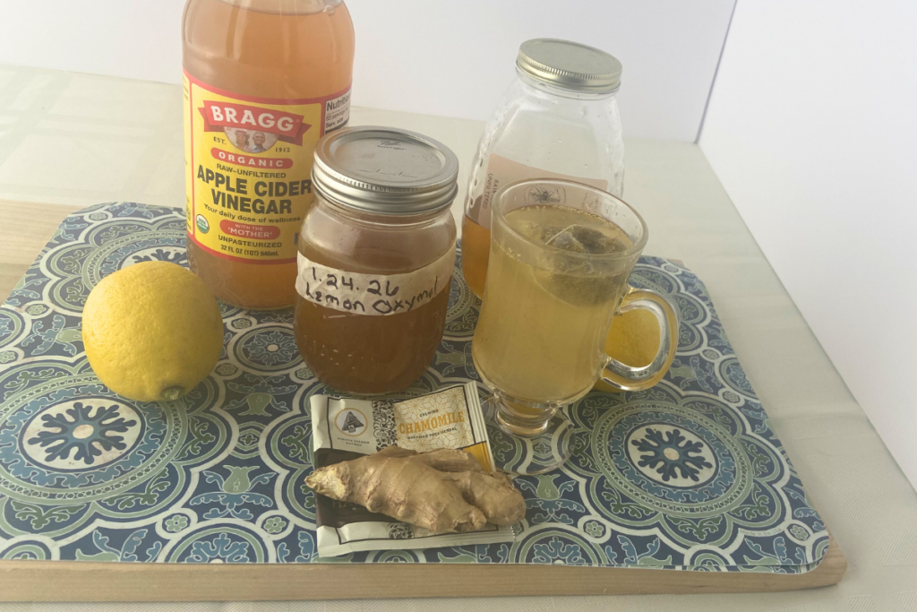 lemon oxymel and apple cider vinegar arrayed with lemon, ginger,honey and a glass of chamomilet ea