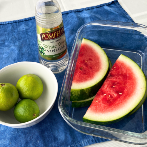 The fresh lime and watermelon displayed with white wine vinegar as ingredients for a watermelon-lime spritzer