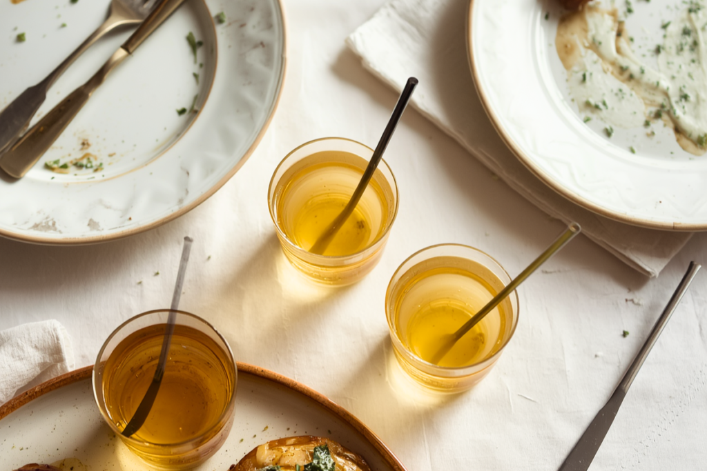 Overhead shot of after-meal empty plates and diluted vinegar drinks with straws